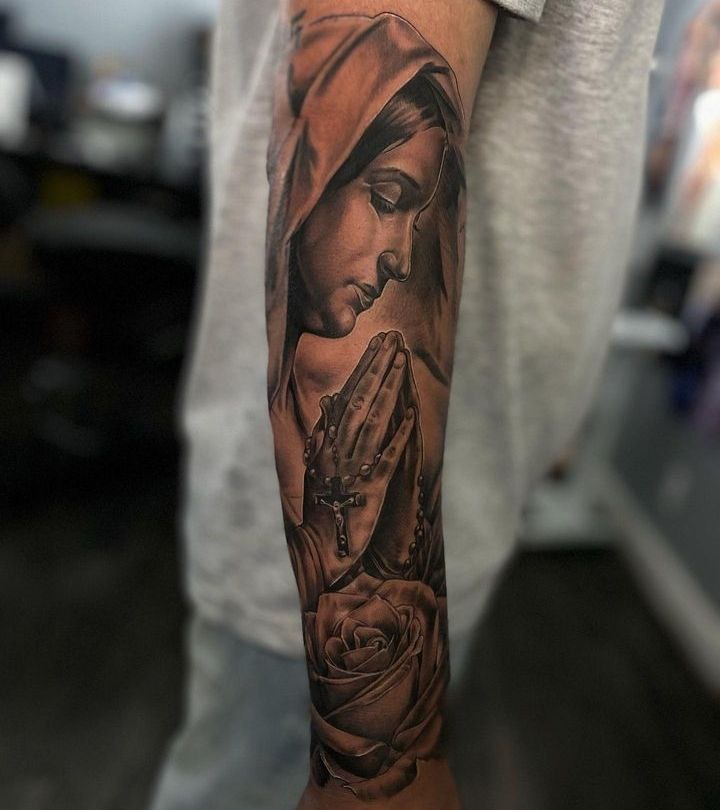Full-sleeve Virgin Mary tattoo praying with rosary beads