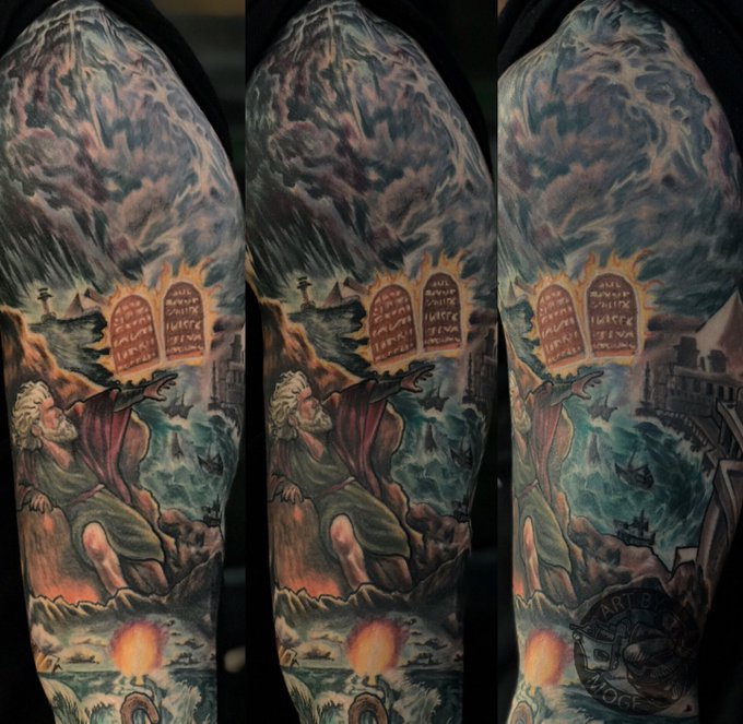 Full-sleeve filled tattoo with the Ten Commandments and Moses